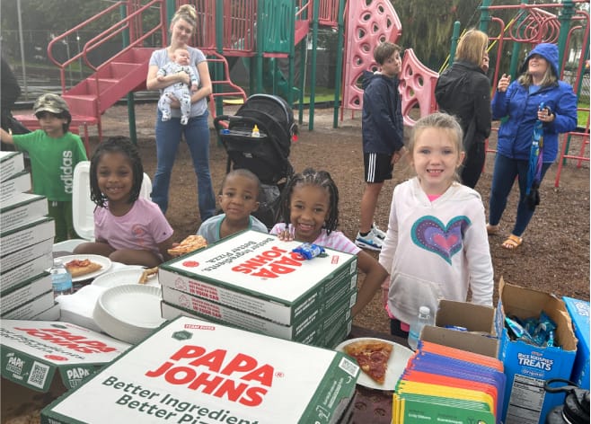 Students eating pizza at the park image