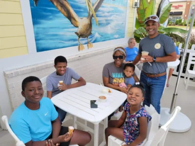 Four kids and two adults eating icecream