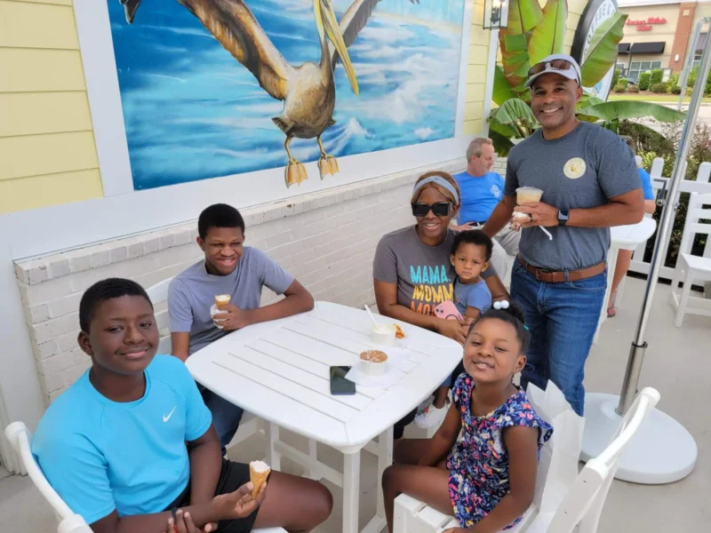Four kids and two adults eating icecream