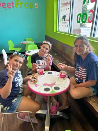 Three people sitting at a colorful Sweet Frog table